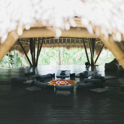 A simple yoga mat and a water bottle on a wooden floor.